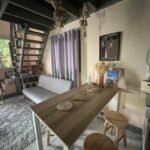 Spacious wooden loft apartment in Baler Philippines featuring a dedicated work from home desk setup with natural light and tropical views.