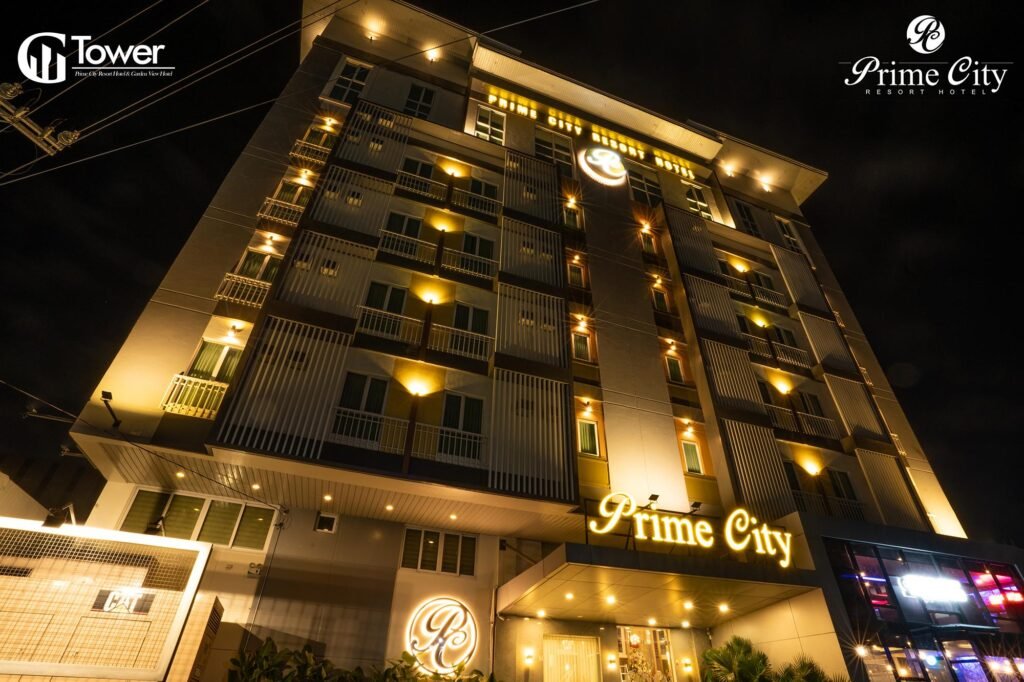 Rooftop swimming pool and modern exterior of Prime City Resort Hotel in Angeles City near Clark, Philippines, showing a vibrant sunset view.
