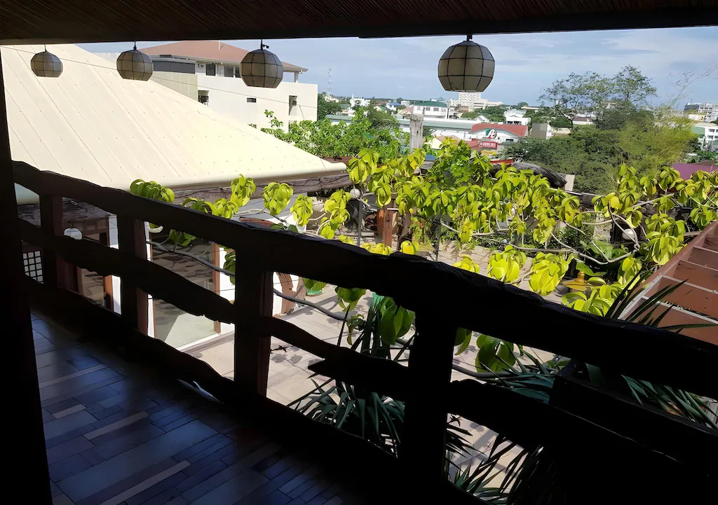 Sun-drenched balcony view overlooking the city and distant landscapes at Gap Plaza Hotel in Bataan, Philippines.
