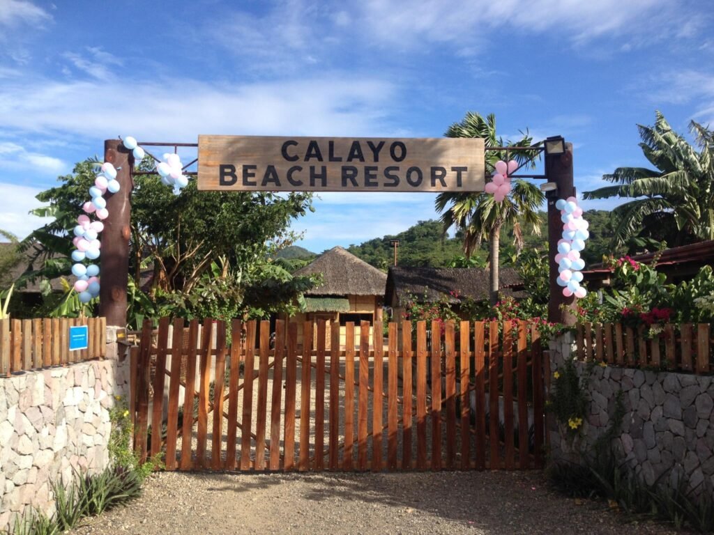 Scenic view of the calm turquoise waters and pristine sandy shore at Calayo Beach Resort in Nasugbu, Batangas, Philippines.