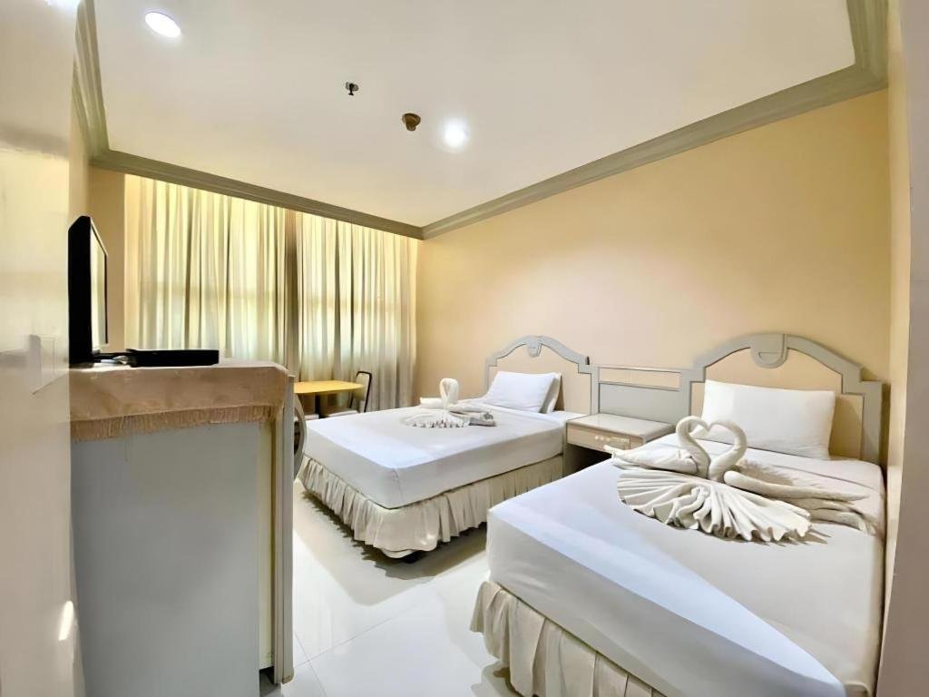 Comfortable and affordable standard room interior at Cebu Northwinds Hotel in Cebu City, Philippines, featuring clean bedding, wooden furniture, and warm lighting.
