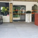 Ground-level view of the outdoor entrance and orange-tiled reception desk at Cess Summer Boutique Hotel.