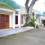 Exterior facade of D Lucky Garden Inn and Suites in Palawan, Philippines, featuring a unique Venice-inspired water feature and vibrant architecture under a tropical sky. SEO Tip: This describes exactly what is in the image for accessibility and Google Images indexing, while naturally incorporating the location and hotel name.