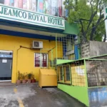 Street-level exterior entrance of Jeamco Royal Hotel in Pasig City, Metro Manila, Philippines, showing the bright yellow facade, green trim, and property signage.