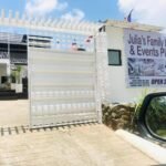 Street-level view of the white gated entrance and informational signage of Julia's Family Hotel and Events Place in Dangcagan, Bukidnon.