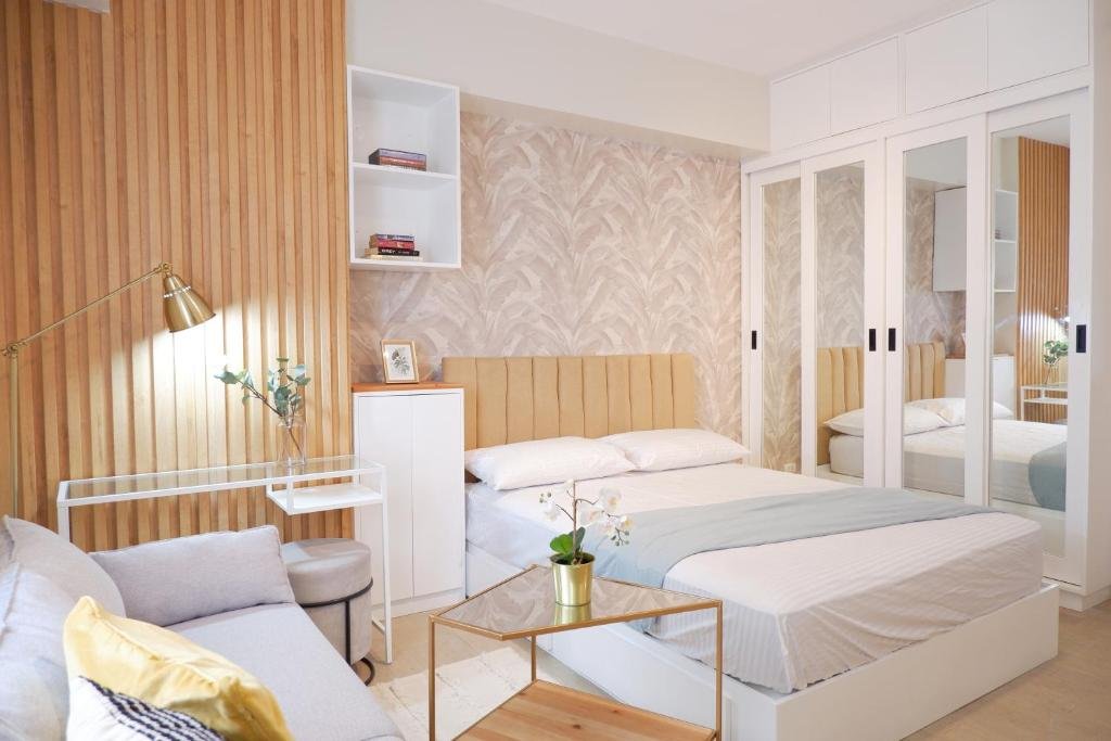 Cozy and modern interior room of a high-rise condo at Manhattan Plaza Tower 1 in Araneta City, Manila, Philippines, featuring a stylish living area, large windows, and a city view.