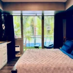 Scenic window view of a sparkling blue swimming pool outside a comfortable vacation rental stay in Manila, Philippines.