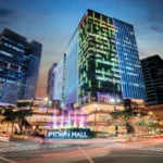 Nighttime long-exposure view of the illuminated Uptown Mall complex and skyscraper towers at One Uptown Residence in Bonifacio Global City.