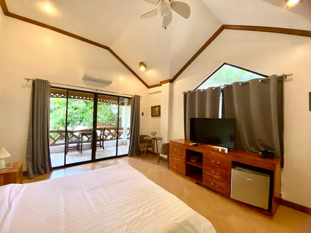 A cozy beachfront room interior at Bruce Beach Resort on Siquijor Island, Philippines, featuring tropical decor and a view of the ocean.