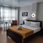 Modern and spacious hotel room at Gap Plaza Hotel in Balanga, Bataan, Philippines, featuring a comfortable bed, warm ambient lighting, and contemporary amenities.