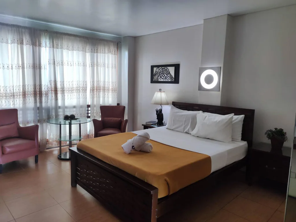 Modern and spacious hotel room at Gap Plaza Hotel in Balanga, Bataan, Philippines, featuring a comfortable bed, warm ambient lighting, and contemporary amenities.