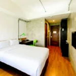 Cozy and affordable air-conditioned room interior at Travelbee Seaside Inn in Bohol, Philippines, featuring clean beds, wooden furnishings, and a welcoming ambiance for travelers.
