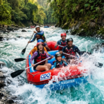 Close-up shot of a group of thrilled travelers wearing helmets and life jackets, paddling together through white water rapids on the Cagayan de Oro River in the Philippines.