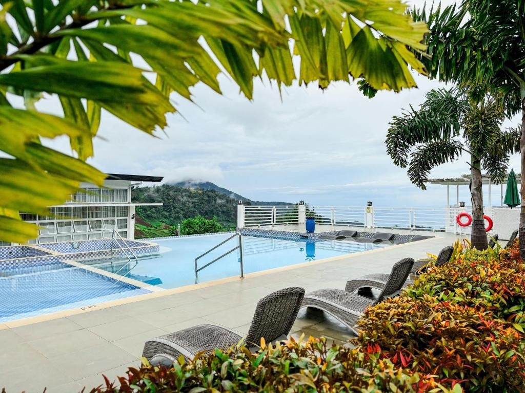 Infinity pool at Montefrio Garden Resort in Digos City overlooking lush green hills and mountains in Davao del Sur, Philippines.