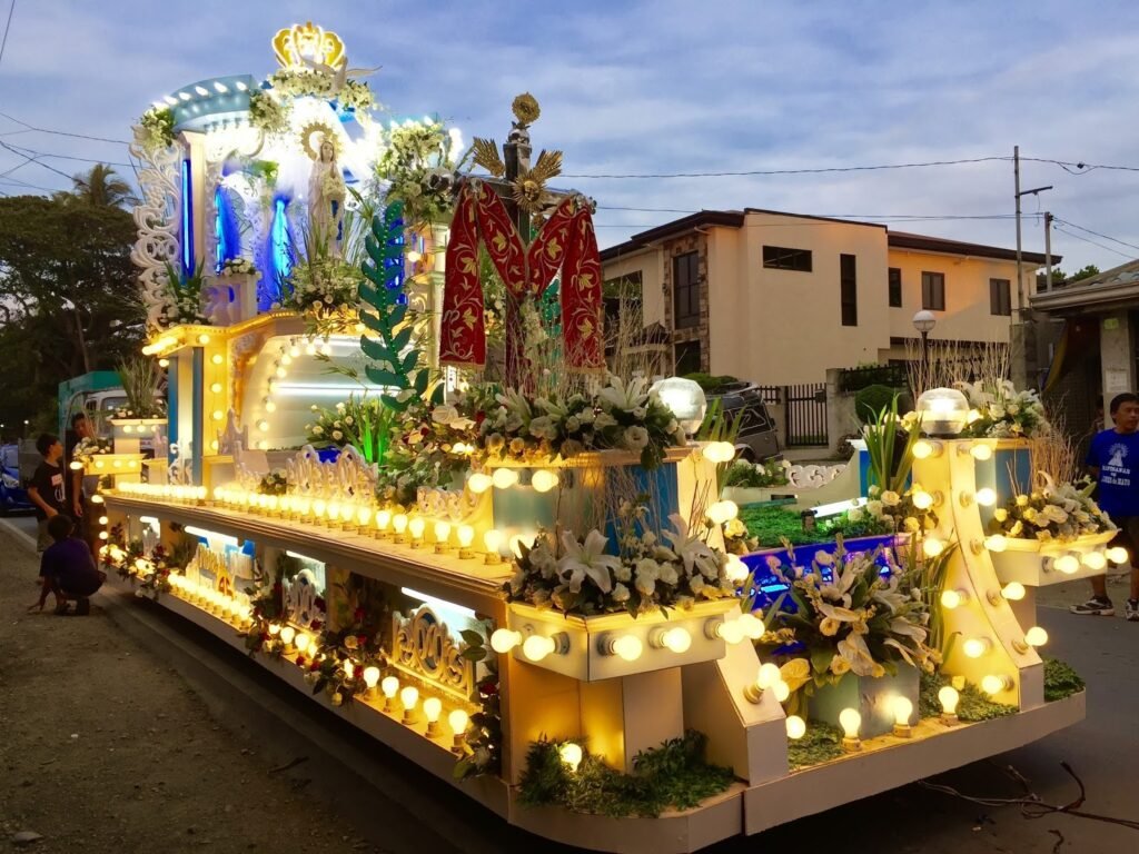 An elaborately decorated and illuminated religious parade float featuring a statue of the Virgin Mary during the Tapusan Festival in Alitagtag, Batangas.